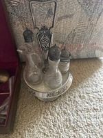 Close-up photo of salt and pepper shaker set on a tray with handle, showing tarnish and wear.