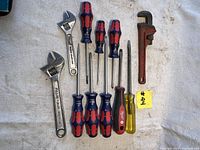 Full view of the 11 piece set showing all screwdrivers and wrenches laid out on white cloth