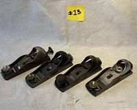 Four Stanley low angle block planes arranged side by side on a beige fabric background under lot label #13