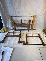 Three vintage wooden bow saws laid on a white background with yellow tags, showing size comparison and overall condition.