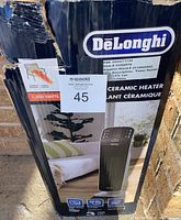 Box showing the DeLonghi brand, 1500 watt ceramic heater model HFX65V15CA with product image and box wear visible