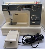 Janome 352 sewing machine and foot pedal with power cord in front, machine body with dials and labels.