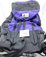 Front view of the purple and black backpack showing the top flap with Mountain Equipment Co-op logo and adjustable straps.