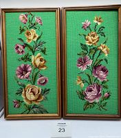 Pair of floral needlepoint artworks in wood frames showing bright green backgrounds with flowers in multiple colors.