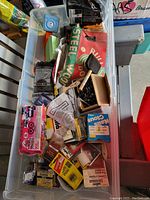 Photo of the plastic bin containing various hand tools, electrical tape, disposable gloves, measuring tape, nails, screws, sandpaper, and other hardware accessories.