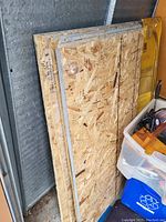 Stack of oriented strand board (OSB) sheets leaning against wall