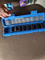 Photo of the socket set inside its blue molded plastic case, showing multiple chrome sockets aligned inside.