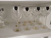 Set of six Lenox crystal wine glasses with the original Lenox labels on the bowls and tags attached to the bases, displayed on a white shelf.