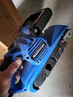 Side view of blue Mastercraft belt sander showing logo and handle design.
