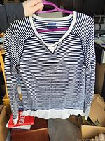Front view of navy blue and white horizontally striped long sleeve Tommy Hilfiger shirt with v-notch neckline, ribbed cuffs and waistband.