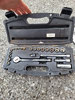 Open black Husky tool case showing socket wrench set including multiple sockets, ratchet wrench, extensions, and universal joint.
