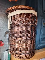 Side view of the wicker laundry basket showing woven wicker construction and fabric liner