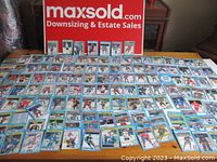 Partial layout of approximately 60 hockey cards spread on table, showing individual player images, team logos, and card backs visible on some.