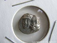 Obverse side of the silver drachm coin showing a double-headed Apollo face.