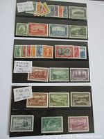Photo showing several rows of antique Canadian stamps with price tags and catalog numbers visible, displayed on a black stock sheet.