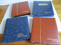 Four hardcover Covercraft albums in brown and blue covers, arranged on table showing spines and covers with labels and gold imprinting