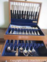 Opened wooden chest showing upper tier of knives and lower tier containing forks and spoons