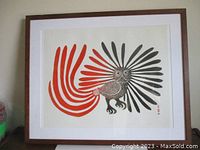 Full frontal view of framed stonecut print depicting red and black stylized owl, white mat and brown wood frame