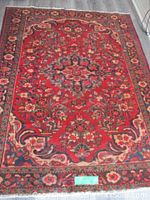 Full view of red Persian Kashan rug with central medallion and floral border