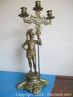 Front view of the solid brass statue depicting Julius Caesar with candelabra on top of the sceptre.