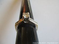 Ring placed on black plastic mandrel showing band profile, setting and prongs.