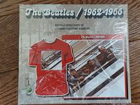 Front view of sealed Beatles 1962-1966 remastered CD and T-shirt set showing red T-shirt with album art and The Beatles 1962-1966 text.