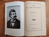 Open book showing portrait of Mark Twain and title page of "Life on The Mississippi"
