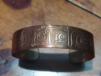 Front view of copper bracelet showing detailed Thunderbird engraving.