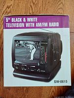 Product box showing front image and model SW-0615, stating 5-inch black and white television with AM/FM radio.