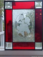 Front view of stained glass panel showing the red stained glass sections, etched white rose center, and beveled glass corners.