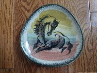 Front view of triangular plate showing Arabian horse motif and speckled green border