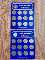 Two blue folders titled Floral Emblems of Canada with 15 collectible coins each from participating Shell Oil dealers.