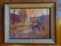 Front view of framed vintage oil painting "The Landing" showing autumn landscape with water and birds, signed by M. Trent.