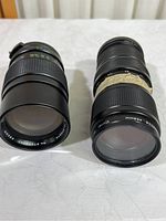 Front view of both Vivitar camera lenses side by side showing overall condition and size difference.
