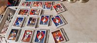 Overall view of 15 vintage football cards in snap lid clear cases laid out on a table showing various players and teams.