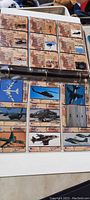 Page of trading cards featuring military aircraft images and detailed info text in each card sleeve.
