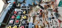 Overview of large lot laid out including Star Wars ships, multiple action figures and weapons, accessories, and parts.