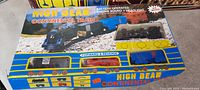 Photo of the large High Beam Continental Train Set in original box showing the black locomotive with engine sound and headlight features, and blue and black freight cars.