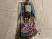 Full view of Barbie Star Light Adventure male doll inside original plastic packaging showing front of package and doll.