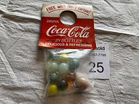 Photo of one sealed set of Coca-Cola promotional marbles in original packaging with red and white header card.