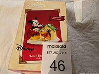 Photo of the Hallmark Keepsake Disney Home Bright Home box with image of Mickey Mouse and Pluto figurine on front and 'Features Movement' tag visible