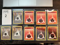 Top-down photo of 10 vintage Pokémon energy cards in plastic sleeves. 4 Metal energy cards, 5 Fire energy cards, and 2 Fighting energy cards are visible.