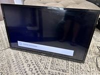 Front view of a black 42-inch Philips TV on a carpeted floor, screen displays 'Channel not available'.