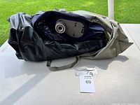Air mattress folded and placed on table, inside carrying/storage bag with handles visible