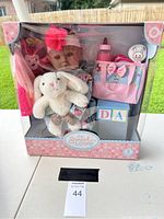 Full view of the unopened My Sweet Love baby doll set in pink and blue box with doll, stuffed bunny, bottle, and storage basket visible.