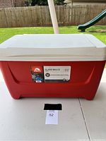 Closed red and white Igloo cooler with label on front showing brand and model information.