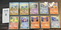 Lot of 10 vintage Pokémon cards laid out in two rows, primarily featuring Fire, Water, and Psychic type Pokémon.