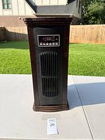 Front view of the wood grain space heater showing digital control panel and vent.