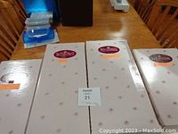 Four unopened boxes containing Ashton Drake Galleries collectible dolls stacked on a table.