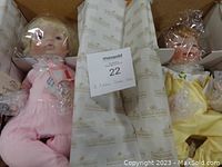 Two Ashton Drake Galleries collectible dolls in original boxes with wrapping and tissue paper, showing overall lot arrangement.